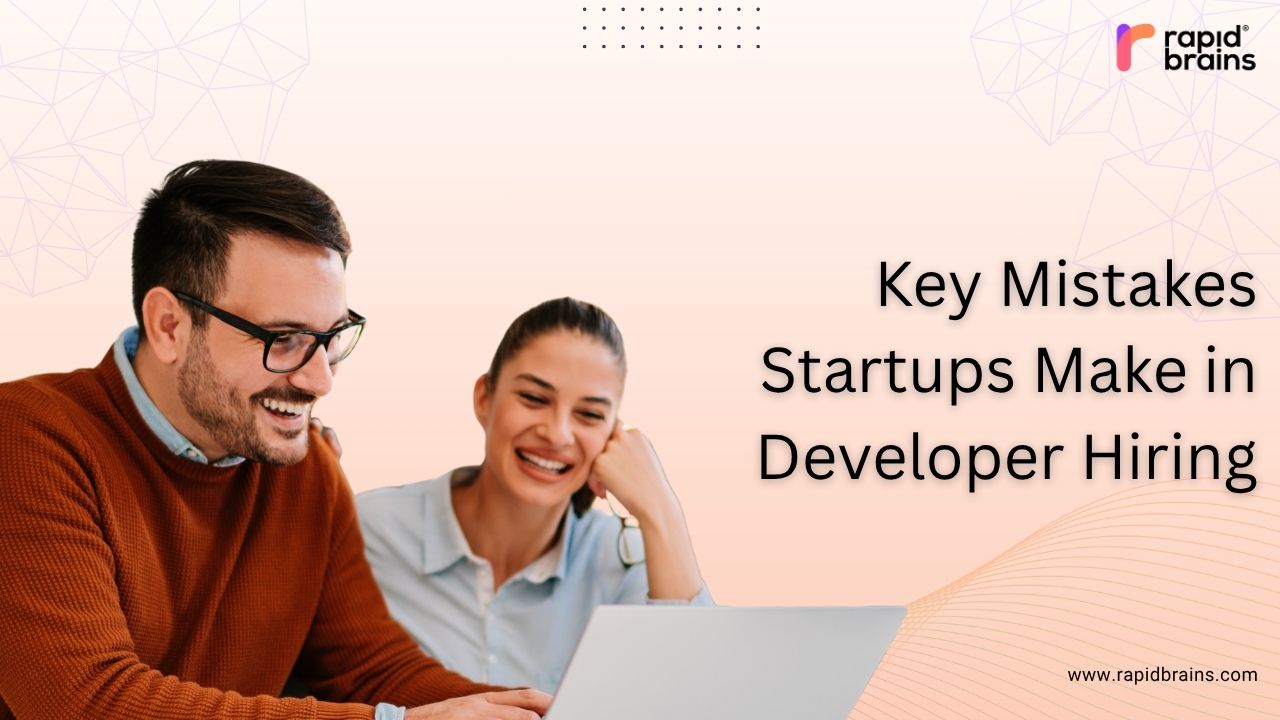 Two people working on a laptop with text "Key Mistakes Startups Make in Developer Hiring"